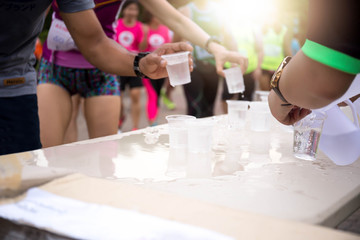 Volunteer people pouring water for athletes marathon runner