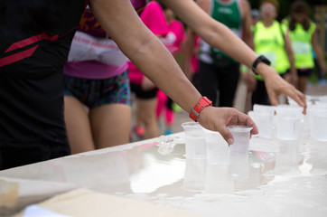 Fototapeta na wymiar Marathon runner hand reaching pick up glass of water