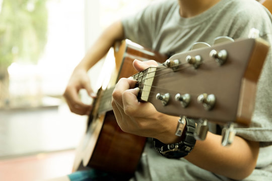 Asian teenager playing the acoustic guitar