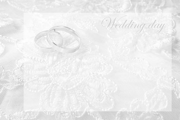 Wedding rings on wedding card, on a white wedding dress