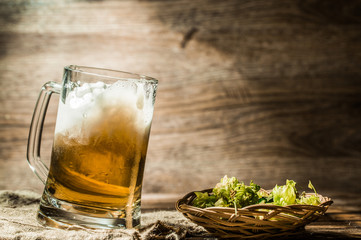Foamy beer poured from cup standing on linen cloth