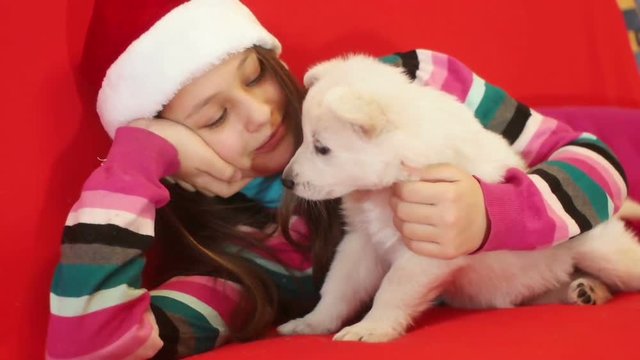 kid in a Santa Claus hat and white puppy  , slow motion