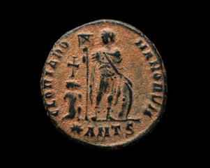 Ancient roman copper coin with person image on it isolated on black