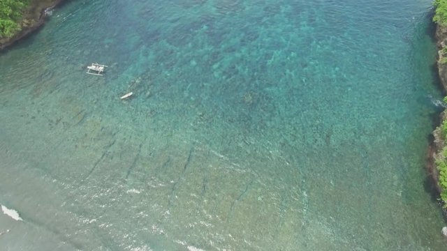 Aerial footage of a beautiful snorkeling bay with shallow water in Nusa Penida, Indonesia.