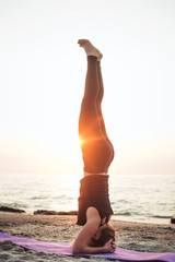 Fototapeta na wymiar young caucasian female practicing yoga on the seaside 