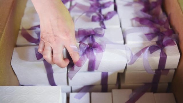 Girl Decorator Puts Gifts in a Cardboard Box for Wedding Guests