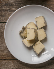 Slices of Danish Blue cheese on an old wooden table, selective focus