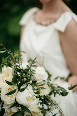 Beautiful wedding bouquet in hands of the bride close-up