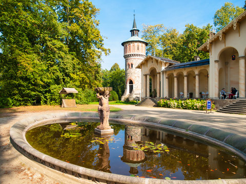 Garden pond with small statue at Orangerie of Sychrov Castle. Park water tower on the background. Bohemian Paradise, Northern Bohemia, Czech Republic