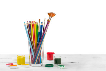 Obraz premium Colored pencils and brushes to draw in glass and watercolor pain