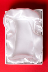 gift box with satin white pillow on red background