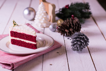 Christmas cake on plate on red fabric on wood background and dec