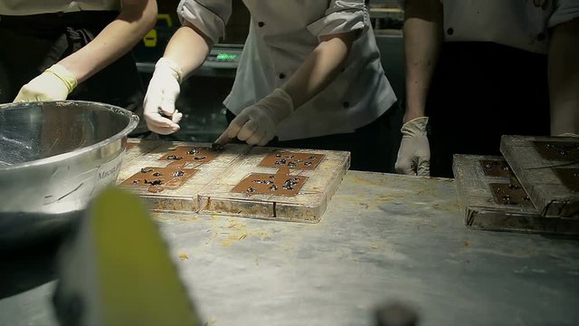 Chef to make delicious candy on chocolate factory of dark chocolate