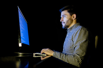 Software developer computer at dark home office