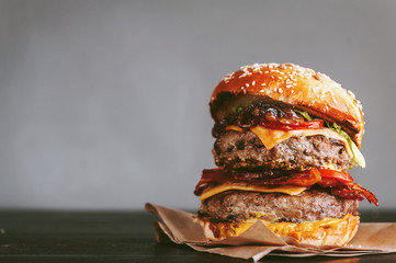 tasty and delicious juicy burger with beef and bacon on a grill