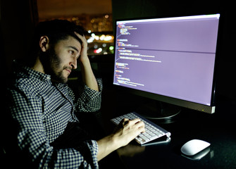 Stressed software developer with computer at home office