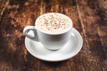 Cup of coffee with ice cream and chocolate on wooden background