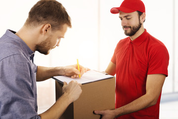 delivery service - man signing delivery receipt of box