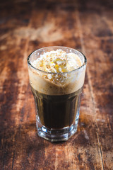 Cup of coffee with ice cream and chocolate on wooden background