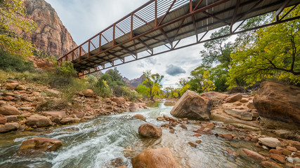 Bridge over the river. Large stones among water flow. The Virgin River flowing through Zion...