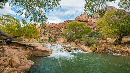 Fototapeta na wymiar Large stones among water flow. The Virgin River flowing through Zion National Park, Utah, USA