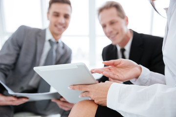 Cropped image of three business people with tablet