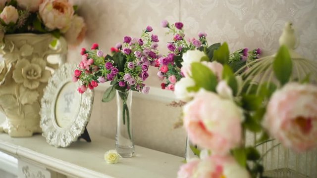bouquet of flowers and a photo frame on shelf in the room
