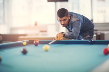 Handsome man playing pool in pub