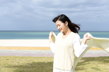 Fototapeta na wymiar 沖縄の美しいビーチで寛ぐ女性