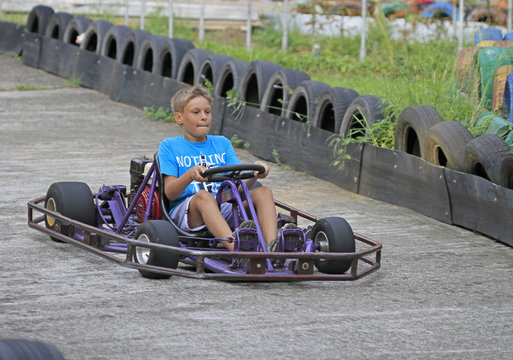 boy is driving a kart on circuit