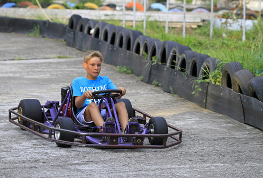 boy is driving a kart on circuit
