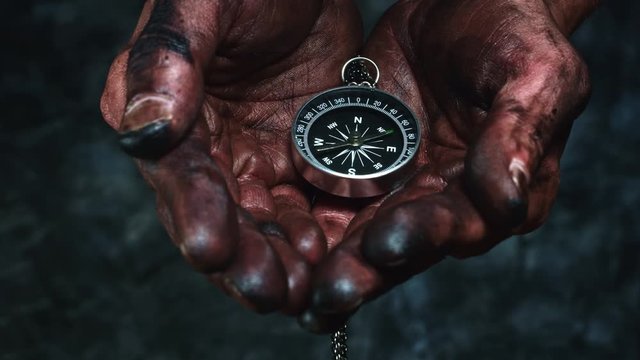 4k Technical Composition of Dirty Mechanic Hands Holding Compass
