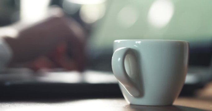 young girl using notebook on a table in cafe and drinking coffee, 4k prores footage