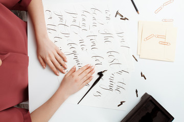 Girl writing calligraphy on postcards. Art design. Above.