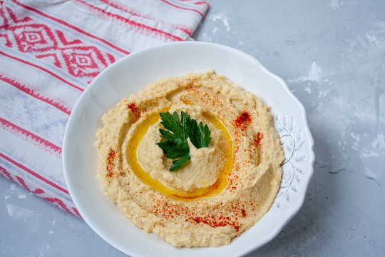 Home classic hummus with celery, pitoy.Vid top on gray concrete background. Vegan Food Concept.