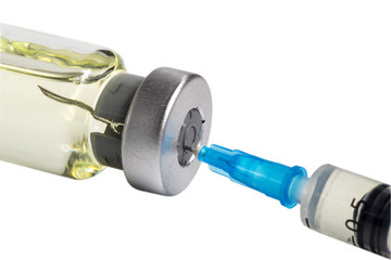 Medicine bottle with yellow drug lying. Needle of  medical syringe inside the cap of the ampule. Isolated on white background. Macro image.
