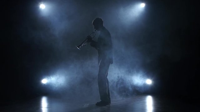 Musician in a smoky studio playing in a trumpet