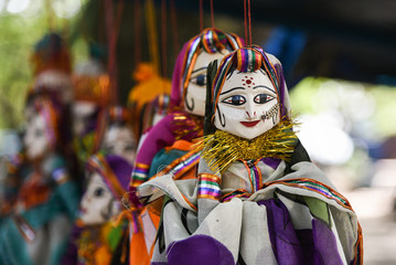 Hand made puppets attached to string in Rajasthan India dolls. Women face with traditional Indian...