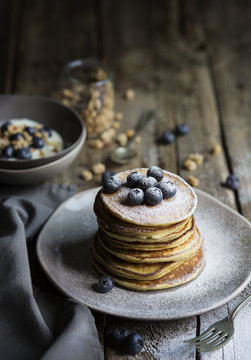 Breakfast table with pancakes served with blueberries and icing