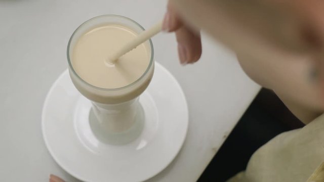 Woman drinking horchata served in cocktail glass with straw. Traditional refreshing beverage in Spain