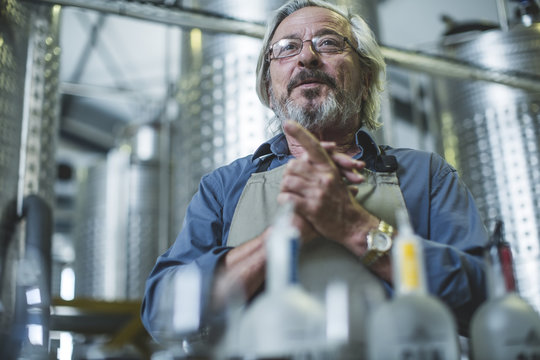 Distiller standing in distillery - Powered by Adobe