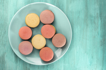 Photo of macarons on teal blue plate with copyspace