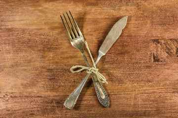 Vintage fork and knife on wooden background