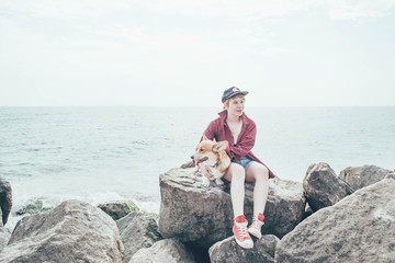 girl with welsh corgi dog on beach