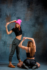 Fototapeta na wymiar The two attractive girls dancing twerk in the studio