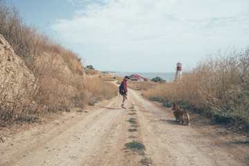 girl with welsh corgi dog on beach