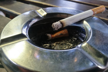 smoking a cigarette, cigarette in hand, ashtray