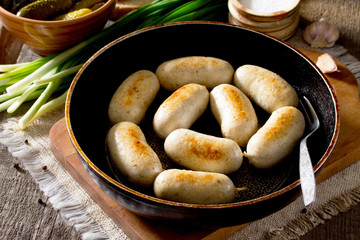 Homemade baked grilled meat chicken sausage in a cast iron pan o