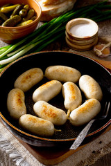 Homemade baked grilled meat chicken sausage in a cast iron pan o