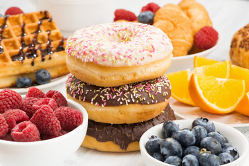 glazed donuts, sweets and fresh berries on table, closeup